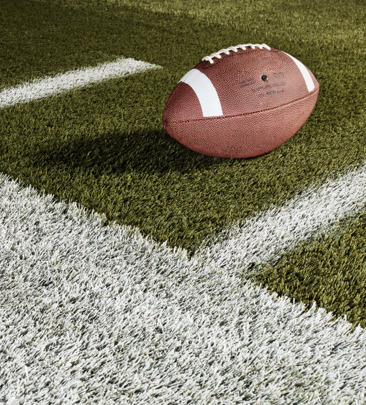 football on on striped green astroturf